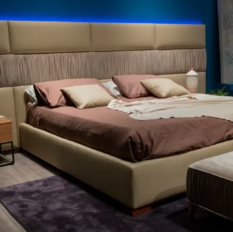 Letto con testiera modulare e morbida in cui le superfici sono scandite dall’alternarsi di rivestimento liscio e plissettato Infinity di Novaluna
