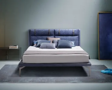 Letto dalla forte personalità con testiera in tessuto imbottito e trapuntato arricchita da cinghie in pelle con fibbie metalliche Firenze di Novaluna